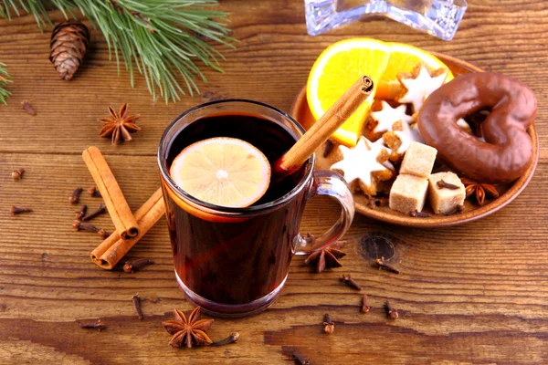 Vino caliente en vaso con rama de canela y dulces — Foto de Stock