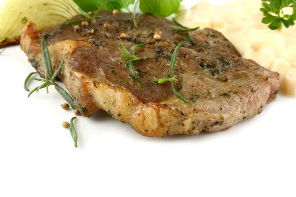 Grilled pork steak with potato salad and herbs — Stock Photo, Image