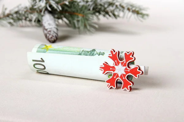 Kerstbonus - honderd euro met rode sneeuwvlok — Stockfoto