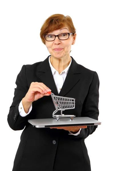 Mature red haired business woman with shopping cart, laptop — Stock Photo, Image