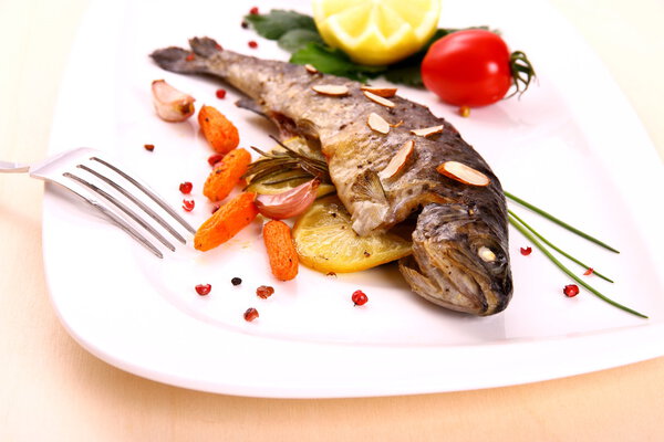 Fried trout with vegetables and split almonds