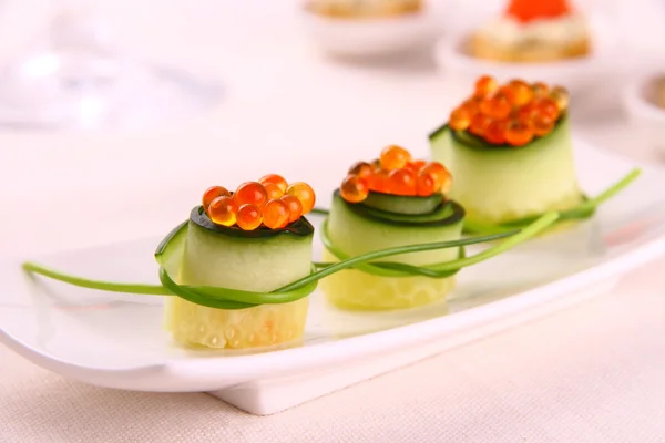 Red caviar on fresh cucumber as snack — Stock Photo, Image