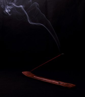 Incense and mystery smoke on black background clipart