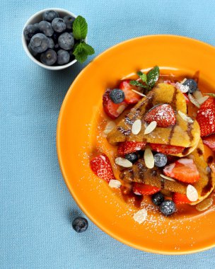 iki kupa ile çilek, yaban mersini ve badem slivers krep