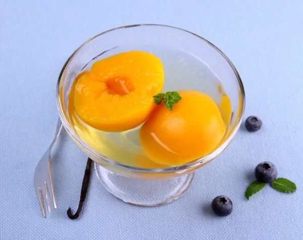 Peach compote in glass bowl with fork, blueberries and vanilla — Stock Photo, Image