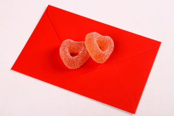 Two hearts from sugar candies on red love letter — Stock Photo, Image