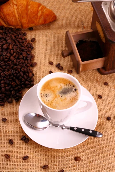 Café em xícara branca, croissant e café moinho — Fotografia de Stock