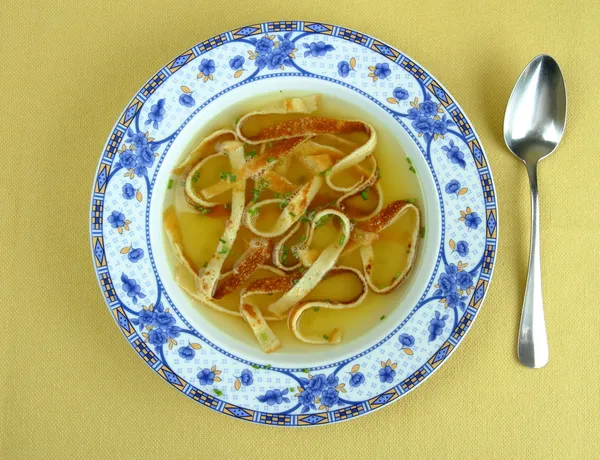 Soupe de crêpes en assiette bleue, mise au point douce — Photo