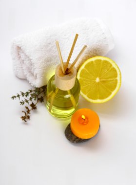 Sarı şişe ile esansiyel yağ, mum ve banyo havluları