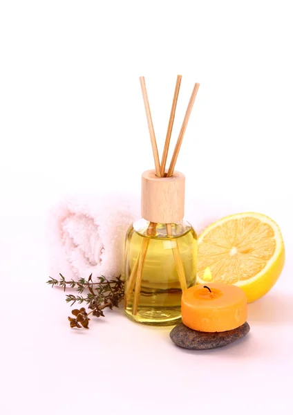 Yellow bottle with essential oil, candle and bath towel — Stock Photo, Image