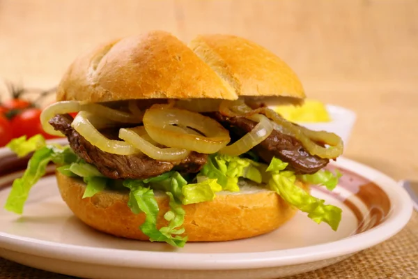 Ochsen semmel - gegrilde rundvlees met uienringen in broodje — Stockfoto