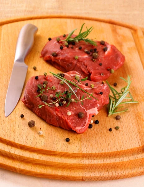 Deux steaks de bœuf juteux avec épices et couteau — Photo