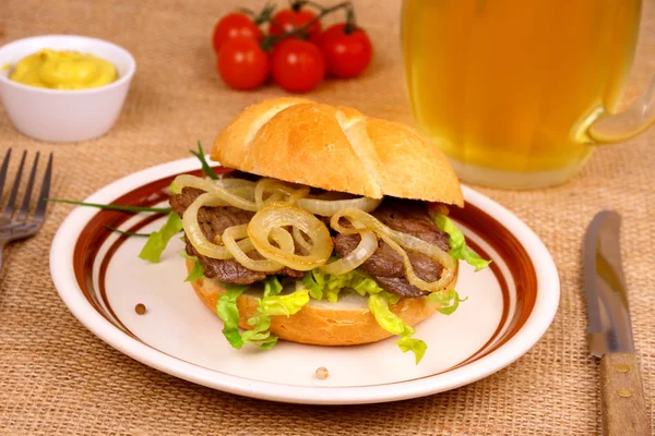 烤的牛肉与洋葱圆环在包子、 芥末、 啤酒 — 图库照片