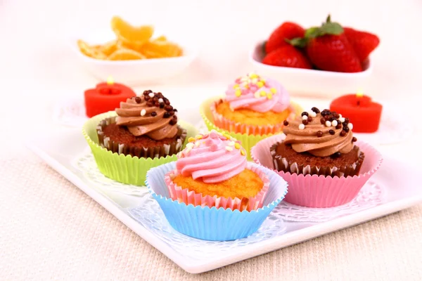 Four appetizing cupcakes on white plate — Stock Photo, Image