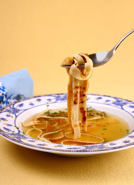 Суп з млинців в синій тарілці, їдять — стокове фото