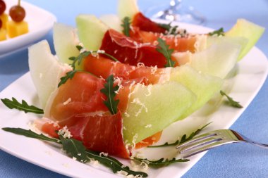 jambon ile olgunlaşmış kavun, parmesan peyniri beyaz tabakta