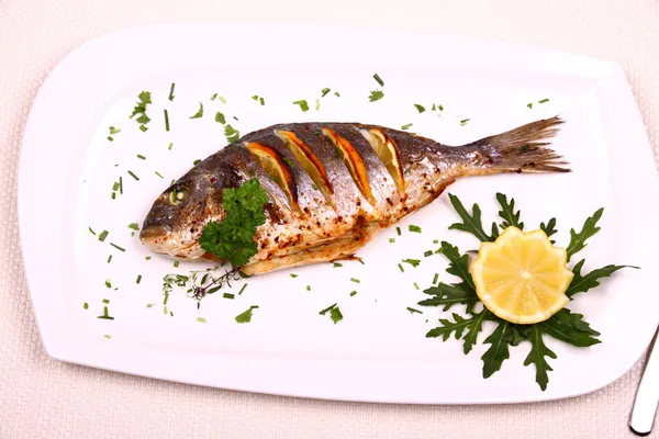 Pesce sarago alla griglia, limone, rucola su piatto bianco — Foto Stock