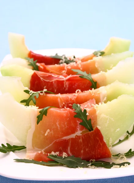 Melone maturo con prosciutto, parmigiano su piatto bianco — Foto Stock