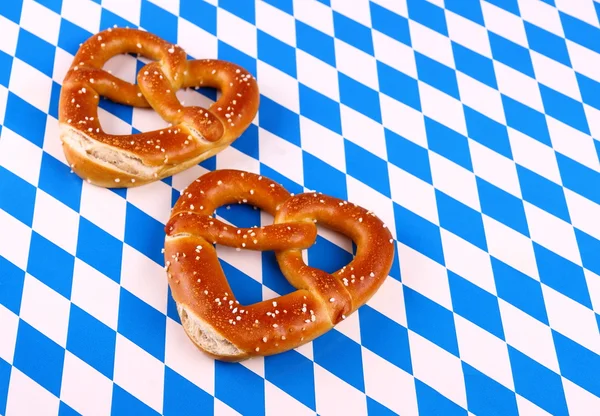 Dos pretzel en forma de corazón sobre fondo blanco azul — Foto de Stock