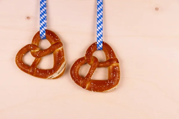 Dois pretzel em forma de coração no fundo de madeira — Fotografia de Stock