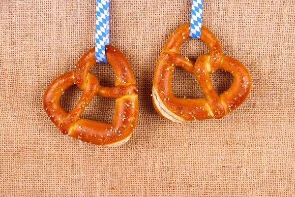 Dos pretzel en forma de corazón sobre fondo de yute —  Fotos de Stock