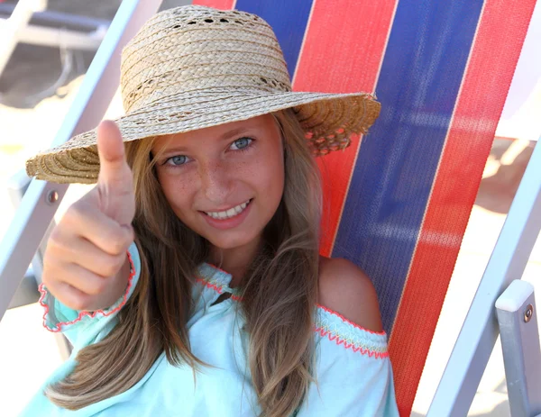 Девушка в шляпе показывает OK на пляже — стоковое фото