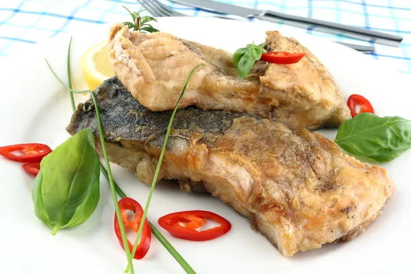 Fried fish on white plate, fork and knife — Stock Photo, Image