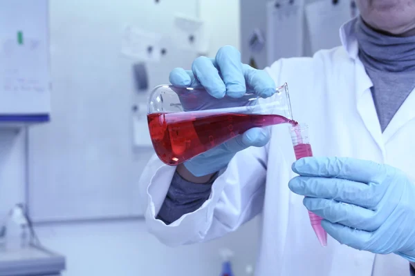 Assistente de laboratório esquece líquido vermelho do tubo de ensaio — Fotografia de Stock