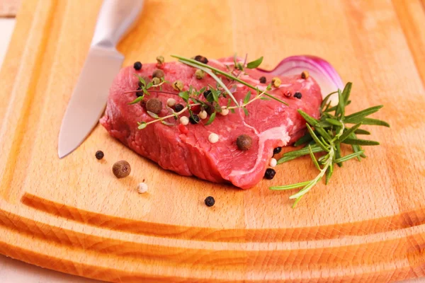 Juicy beef steak with spices and steel knife — Stock Photo, Image