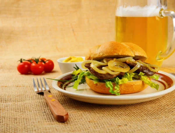 Gegrilde rundvlees met UI ringen in broodje, bier, mosterd — Stockfoto