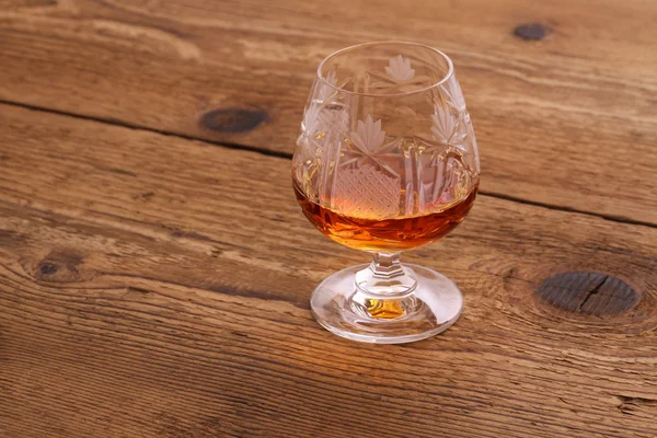 Luxure Cognac in decorated crystal glass on wood — Stock Photo, Image