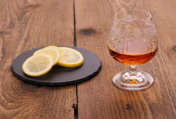 Luxure Cognac in decorated crystal glass and lemon — Stock Photo, Image