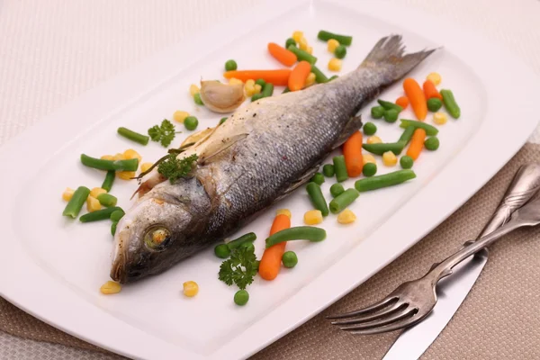 Fried whole sea bass with vegetables and lemon — Stock Photo, Image