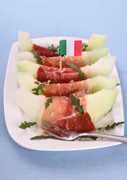 Rebanada de melón maduro con jamón, parmesano y bandera de Italia — Foto de Stock