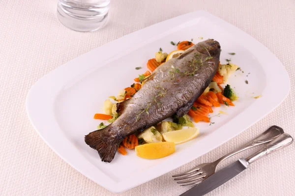 Fried whole trout with vegetables and cutlery — Stock Photo, Image