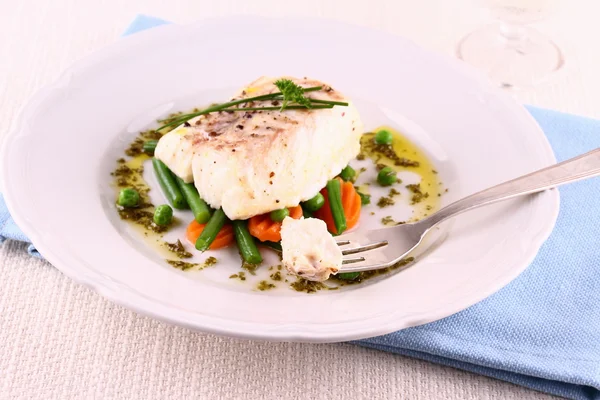 Cod fillet on fork with green beans, peas, parsley, olive oil — Stock Photo, Image