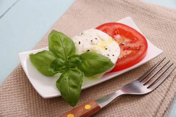 Basil leaf, mozzarella cheese, tomato slice and fork — Stock Photo, Image