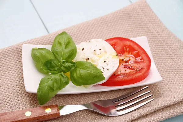 Basil leaf, mozzarella cheese, tomato slice, fork — Stock Photo, Image