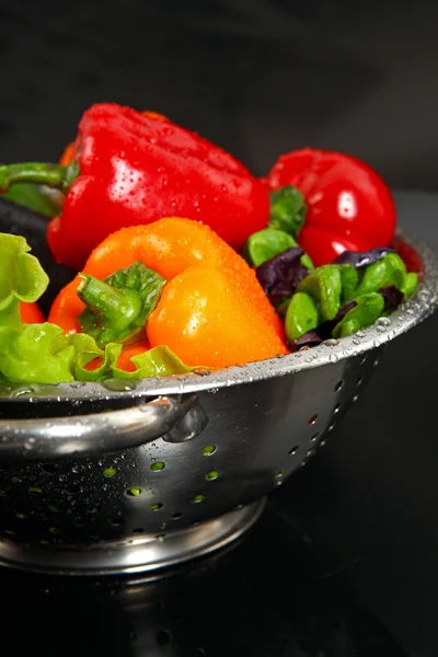 新鲜金属漏勺孤立在黑色背景中洗新鲜蔬菜 — 图库照片