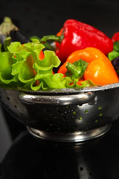 新鲜金属漏勺孤立在黑色背景中洗新鲜蔬菜 — 图库照片