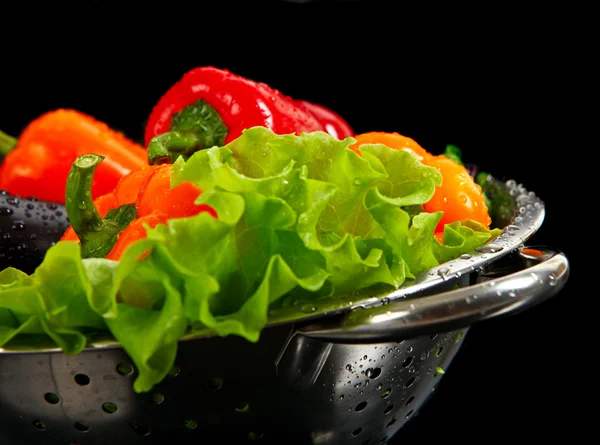 Frisch gewaschenes frisches Gemüse in einem Metallsieb isoliert über schwarzem Hintergrund. — Stockfoto