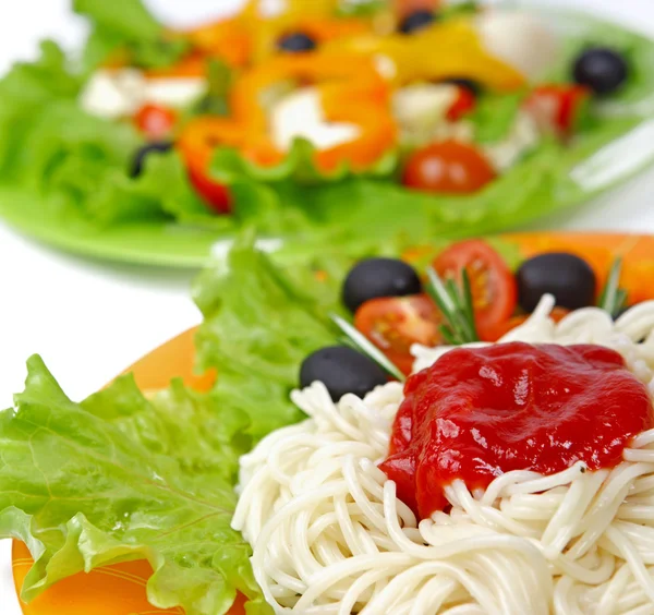 Паста-спагетти с помидорами черри и салатом — стоковое фото