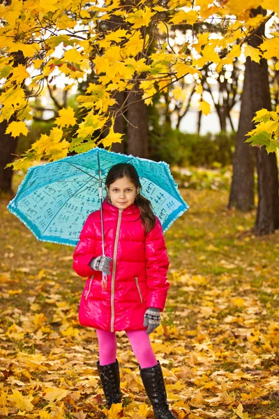 Liten flicka ha kul att spela med gyllene löv — Stockfoto