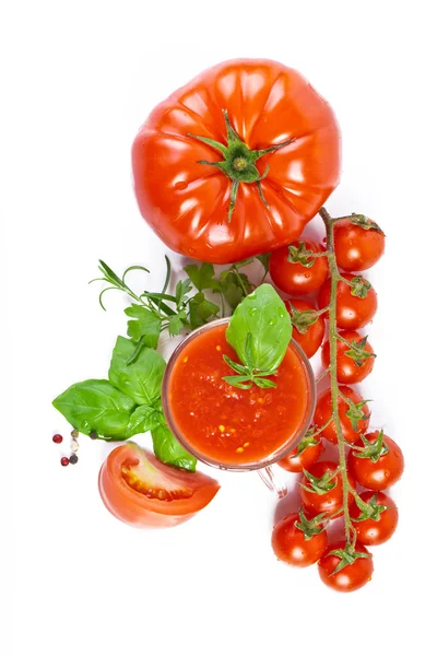Copo cheio de suco de tomate fresco e plantas perto dele . — Fotografia de Stock