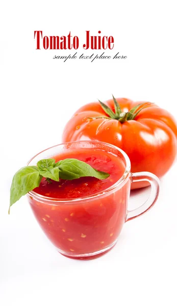 Copo cheio de suco de tomate fresco e plantas perto dele . — Fotografia de Stock