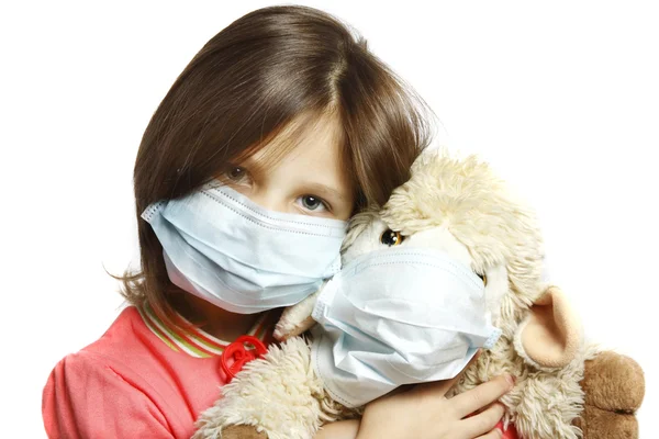 Niña con juguete usando una máscara protectora —  Fotos de Stock