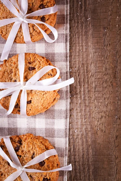 Stacked chocolate chip cookies on wooden table — Stock Photo, Image