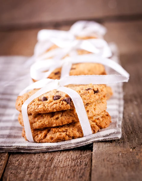 Stacked chocolate chip cookies on wooden table — Stock Photo, Image