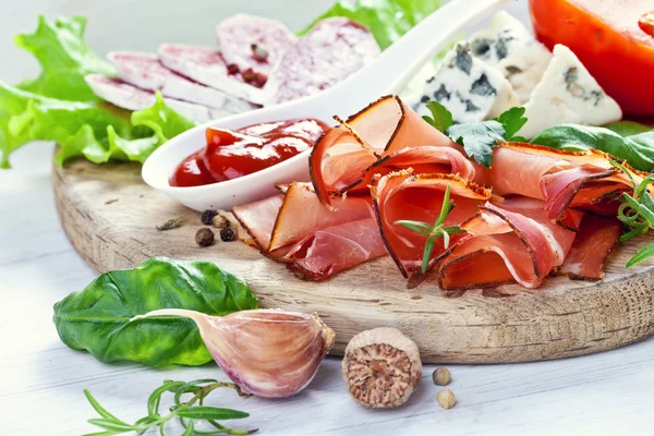 Prosciutto with salami, cheese and basil — Stock Photo, Image