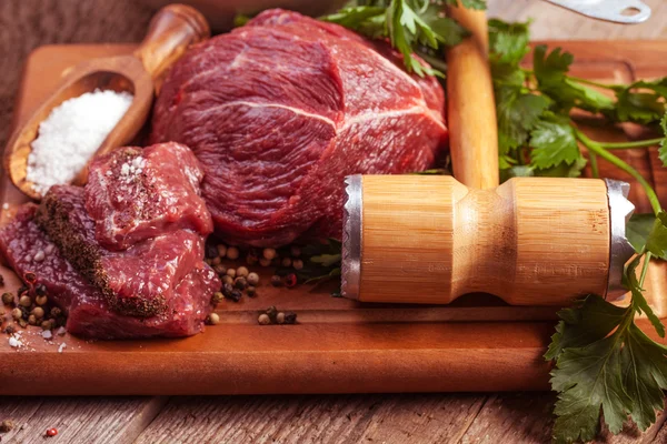 Raw meat on board with herbs — Stock Photo, Image